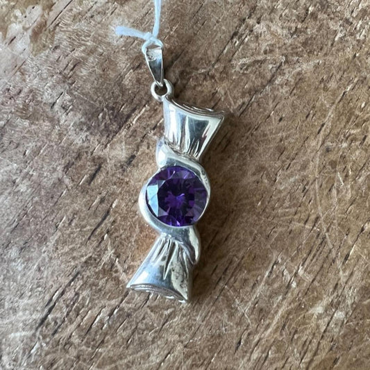 The round purple CZ in the Ribbon Pendant - Sterling Silver